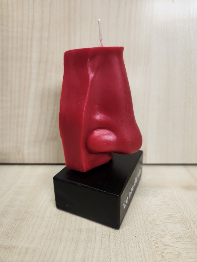 Bougie en forme de nez sur socle en bois vue de côté