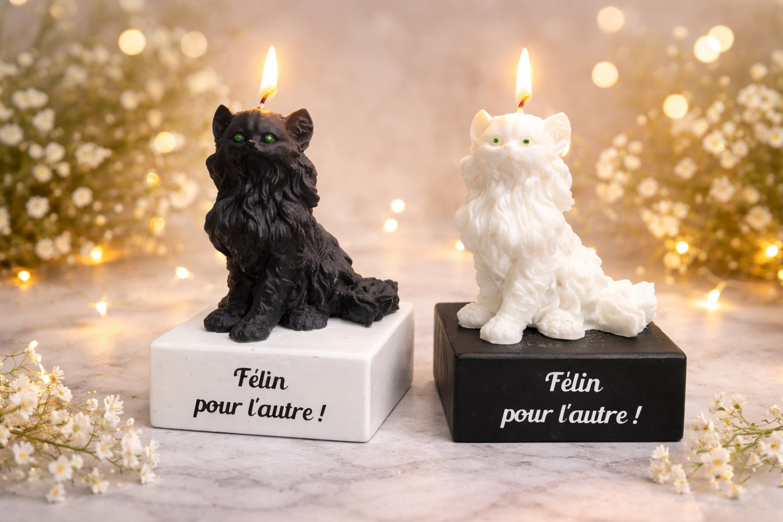 Deux bougies originales en forme de chats, l’une noire et l’autre blanche, allumées sur des socles assortis avec l’inscription « Félin pour l’autre », sur un fond décoratif lumineux et chaleureux