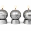 Trois bougies boules de pétanque effet métal allumées sur fond neutre blanc